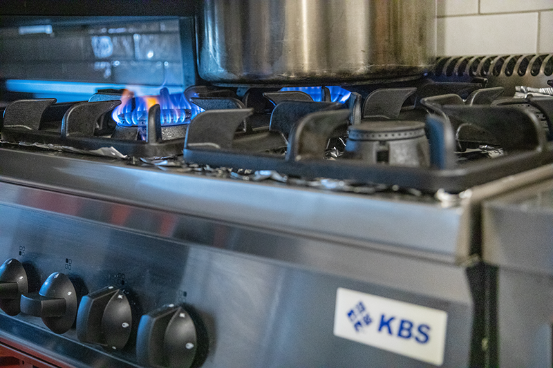KBS Gasherd der Kochserie Ready 700 in Nutzung mit sichtbarer Flamme und Kochtopf. Vorderansicht mit Bedienknebeln. Einsatzbereich: Gastronomie, Restaurantküche.