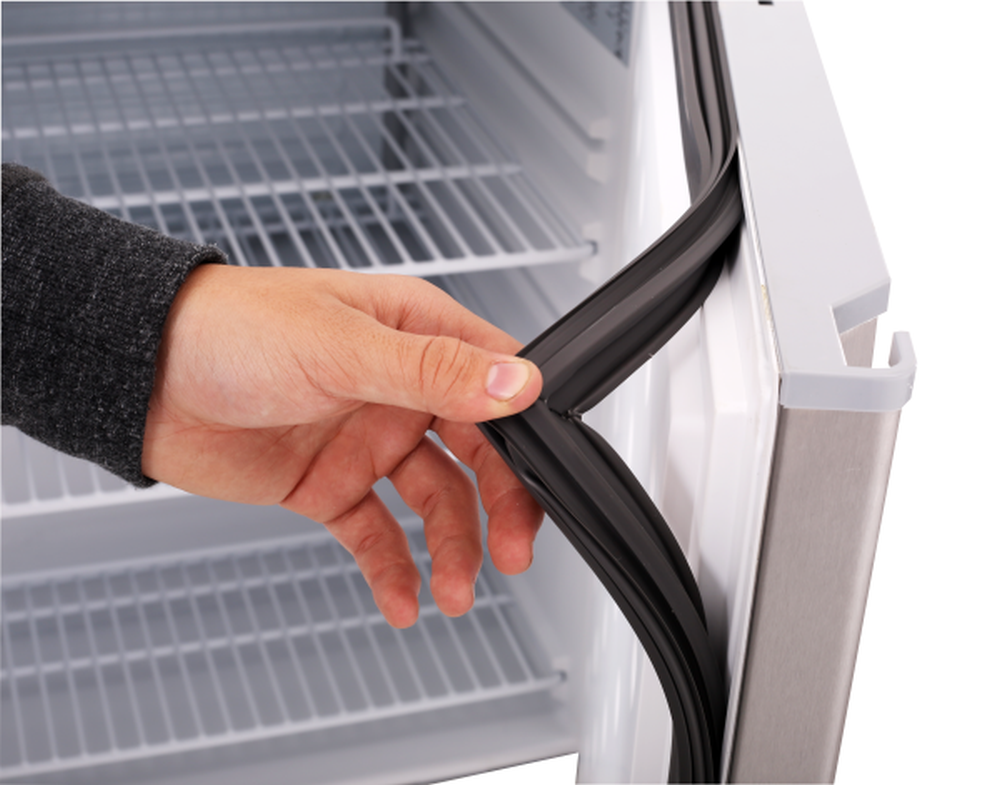 KBS Edelstahlschrank mit geöffneter Tür und Hand, die die flexible Türdichtung kontrolliert. Fokus auf Hygiene und Wartungsfreundlichkeit.