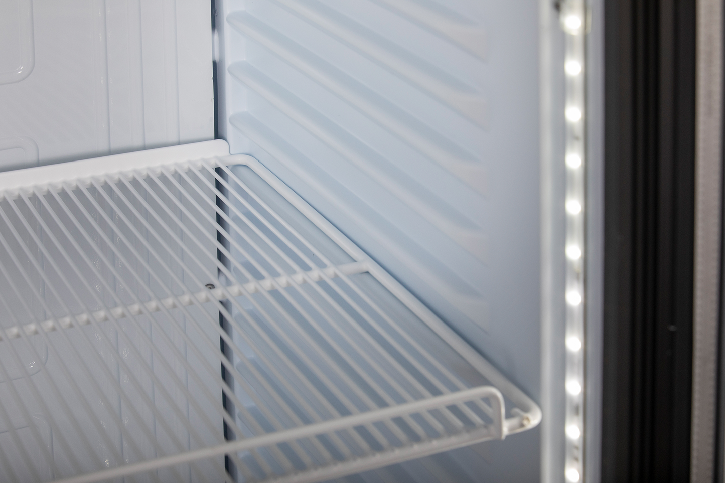 KBS Glastürkühlschrank 375 GDU Innenansicht aus schräger Perspektive mit leerem weißen Gitterrost und seitlicher LED-Beleuchtung, geeignet für Gastronomie, Pizzeria oder Bäckerei.